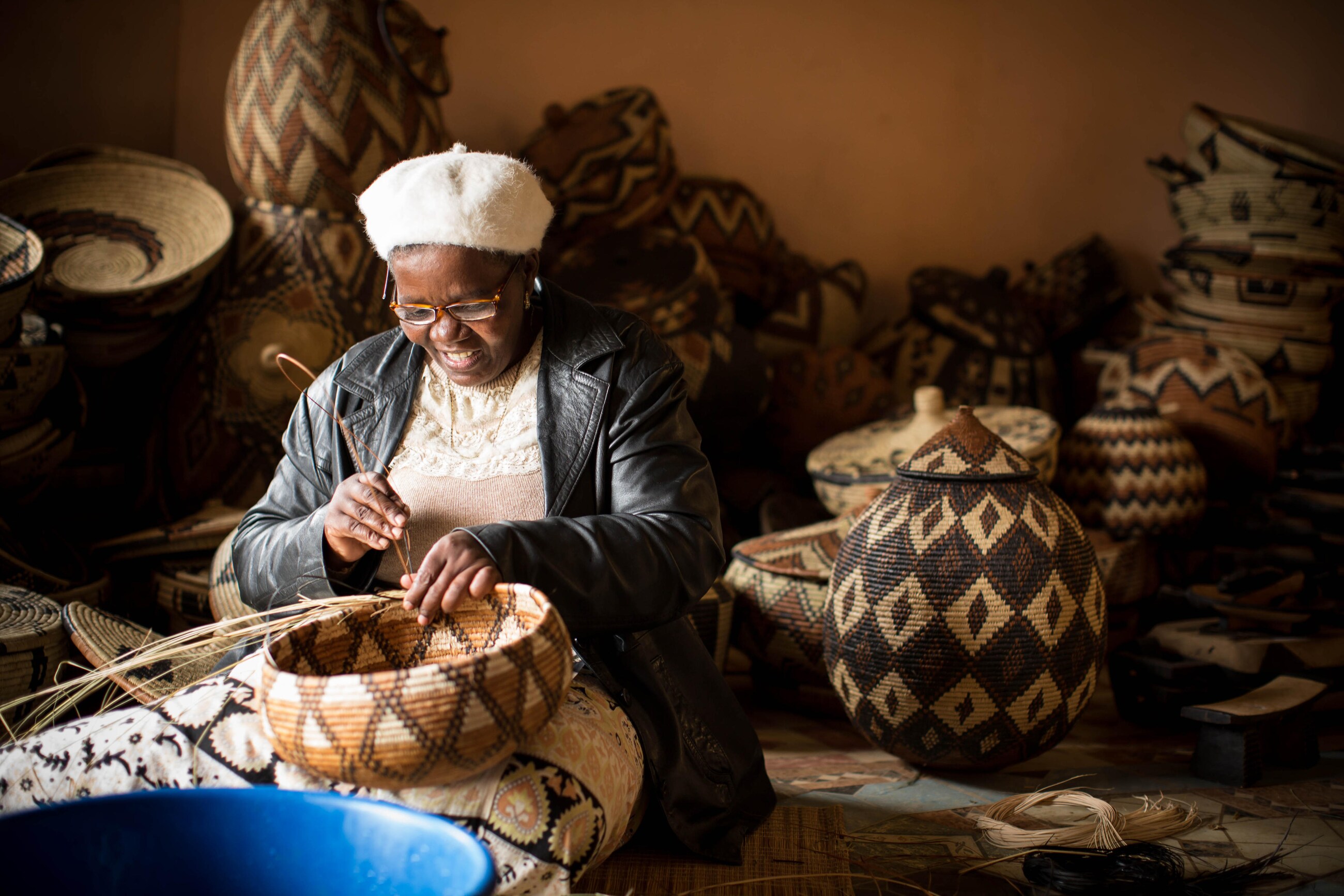 African woman weaving a basket